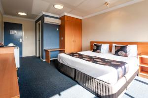 a hotel room with a large bed and a desk at Black Buffalo in Hobart