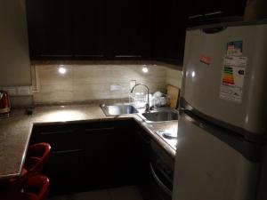 een keuken met een witte koelkast en een wastafel bij Hostal Quinta Normal in Antofagasta