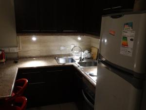 a kitchen with a white refrigerator and a sink at Hostal Quinta Normal in Antofagasta
