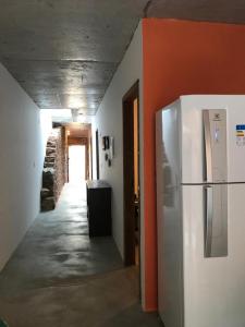 a hallway with a white refrigerator in a room at Casa da Vila Santo Antônio - 3 suítes in Piranhas