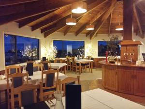 ein Restaurant mit Tischen, Stühlen und Fenstern in der Unterkunft Kimi Ora Eco Resort in Kaiteriteri