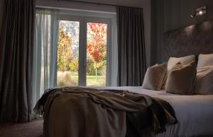 a bedroom with a bed and a large window at Queenstown Country Lodge in Queenstown