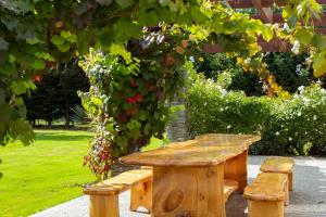 una mesa de picnic de madera y bancos bajo un árbol en Queenstown Country Lodge en Queenstown