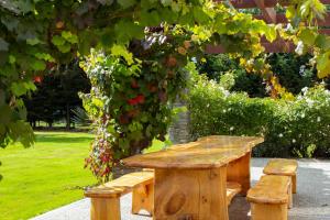 una mesa de picnic de madera y bancos bajo un árbol en Queenstown Country Lodge, en Queenstown