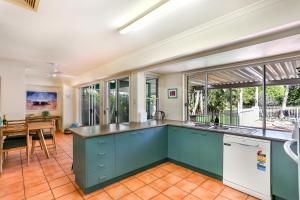 an open kitchen with blue cabinets and a dining room at Clouds End in Noosaville