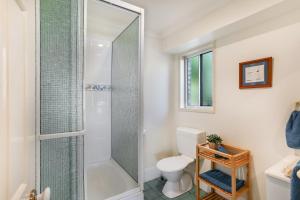 a bathroom with a shower and a toilet at Clouds End in Noosaville