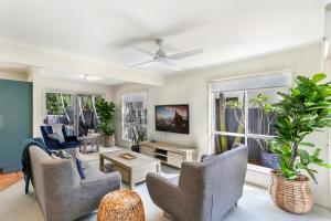 a living room with two chairs and a table at Clouds End in Noosaville