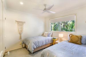 a bedroom with two beds and a window at Clouds End in Noosaville +15 photos