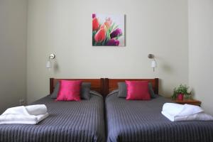 Duas camas com almofadas cor-de-rosa num quarto em Hotel Chojnik em Podgórzyn
