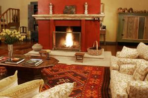 a living room with a fireplace and a table at Hotel Fazenda Santa Marina in Santana dos Montes