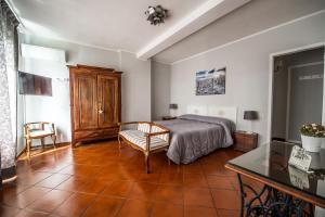 a bedroom with a bed and a chair and a table at Treinin Guest Rooms in Gavi