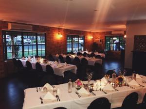 a dining room with white tables and black chairs at Clermont Country Motor Inn in Clermont