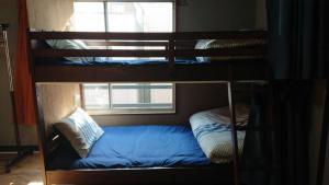 two bunk beds in a room with a window at GUEST HOUSE SaKURa in Tokyo
