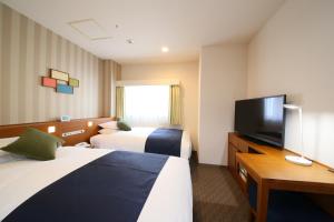 a hotel room with two beds and a television at Shinjuku Washington Hotel in Tokyo