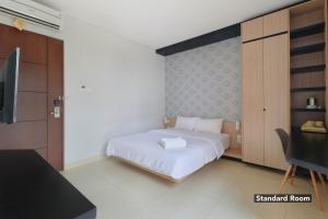 a bedroom with a bed and a tv in it at Plaza 54 Residence Jakarta in Jakarta