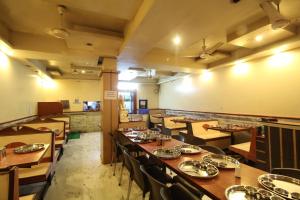 a dining room with wooden tables and chairs at Hotel Shivkrupa in Pune