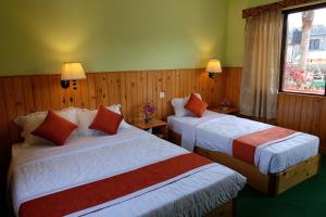 A bed or beds in a room at New Pokhara Lodge - Pokhara Lakeside