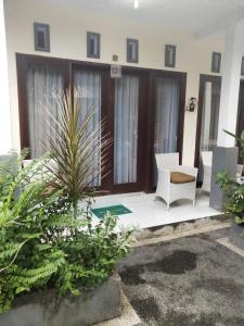 un patio de una casa con una silla y plantas en BBS Homestay, en Nusa Lembongan