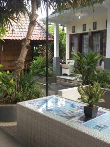 a pool in front of a house with plants at BBS Homestay in Nusa Lembongan