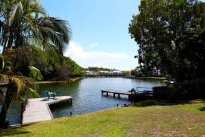 a river with a dock and chairs on it at Clouds End in Noosaville