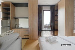 a bedroom with a white bed and a kitchen at Plaza 54 Residence in Jakarta