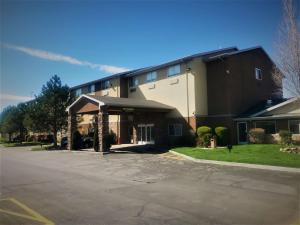 Un edificio con un estacionamiento enfrente. en West Valley Inn, en West Valley City