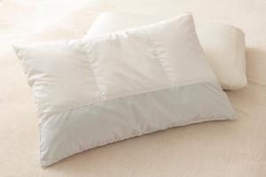 a white pillow sitting on top of a bed at remm Tokyo Kyobashi in Tokyo