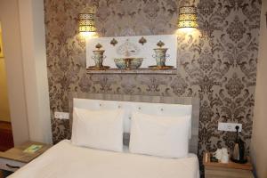 a bed with two white pillows and two plates on a wall at Ararat Hotel in Istanbul