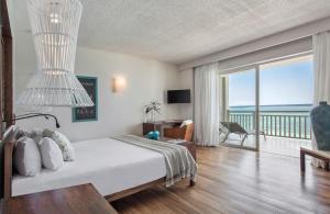 a bedroom with a bed and a balcony with the ocean at Solana Beach Mauritius - Adults Only in Belle Mare +86 photos
