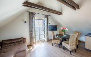 a living room with a table and chairs and a television at Vila Preiloja in Neringa