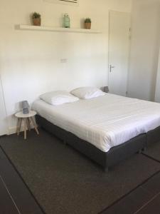 a large bed in a room with a table at De Dieskant in Den Bosch