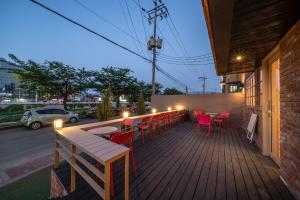 a deck with tables and chairs on a building at Chuncheon Bom Stay in Chuncheon