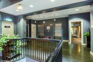 a lobby with blue walls and a staircase with plants at Best Western Melbourne City in Melbourne