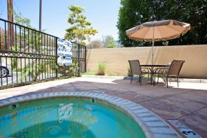 a small pool with a table and an umbrella at La Quinta by Wyndham NE Long Beach/Cypress in Hawaiian Gardens