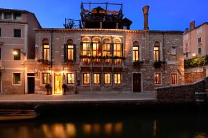 a large brick building with lights on at Palazzetto Madonna in Venice
