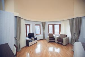 a hotel room with a living room with a television and a couch at Goy Gol Lake Resort in Goygol