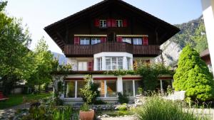 a house with a balcony on top of it at Adventure Guesthouse Interlaken in Interlaken