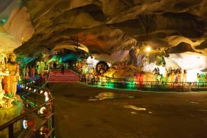 a tour of a cave with people inside of it at Lavana Hotel Batu Caves in Batu Caves