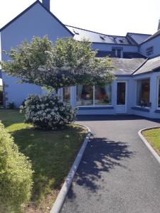 une maison avec un arbre dans l'allée dans l'établissement Hotel au Moyne De Saire, à Réville