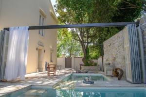 an outdoor patio with a pool and a table at Carpofoli Corfu Town Serviced Luxury Suites in Corfu