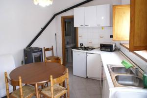 a small kitchen with a table and a sink at Casa Poli Bolzoni in San Marcello Pistoiese