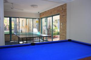 a living room with a pool table and a table at Aqua Villa Holiday Apartments in Coffs Harbour