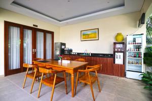 comedor con mesa de madera y sillas en Toya Villa Ubud, en Ubud