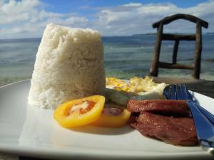 a plate of food with rice and meat and a lemon at RSK Beach and Accommodation in Dapa