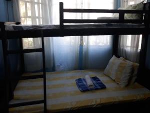 CVNB guesthouse في سان خوان: سرير في سرير بطابقين مع هاتف عليه