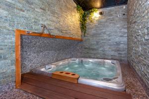 a jacuzzi tub in a bathroom with a brick wall at Winter & Summer Resort in Ždiar