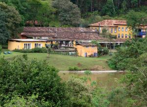 un gruppo di edifici in un campo vicino a un fiume di Hotel Fazenda Santa Marina a Santana dos Montes