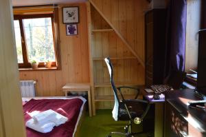a small room with a bed and a desk with a laptop at MSC Apartments Honeymoon in Zakopane