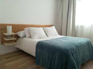 sypialnia z łóżkiem z niebieskim kocem i oknem w obiekcie LANCES I. Terrace, beach and pool w mieście Tarifa +8 zdjęć