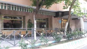 a restaurant with tables and chairs in front of a building at Hotel Paraíso in Lanjarón